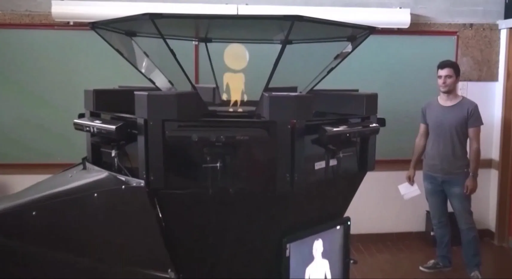 A person facing the PRHOLO 360° holographic structure showing an animated character