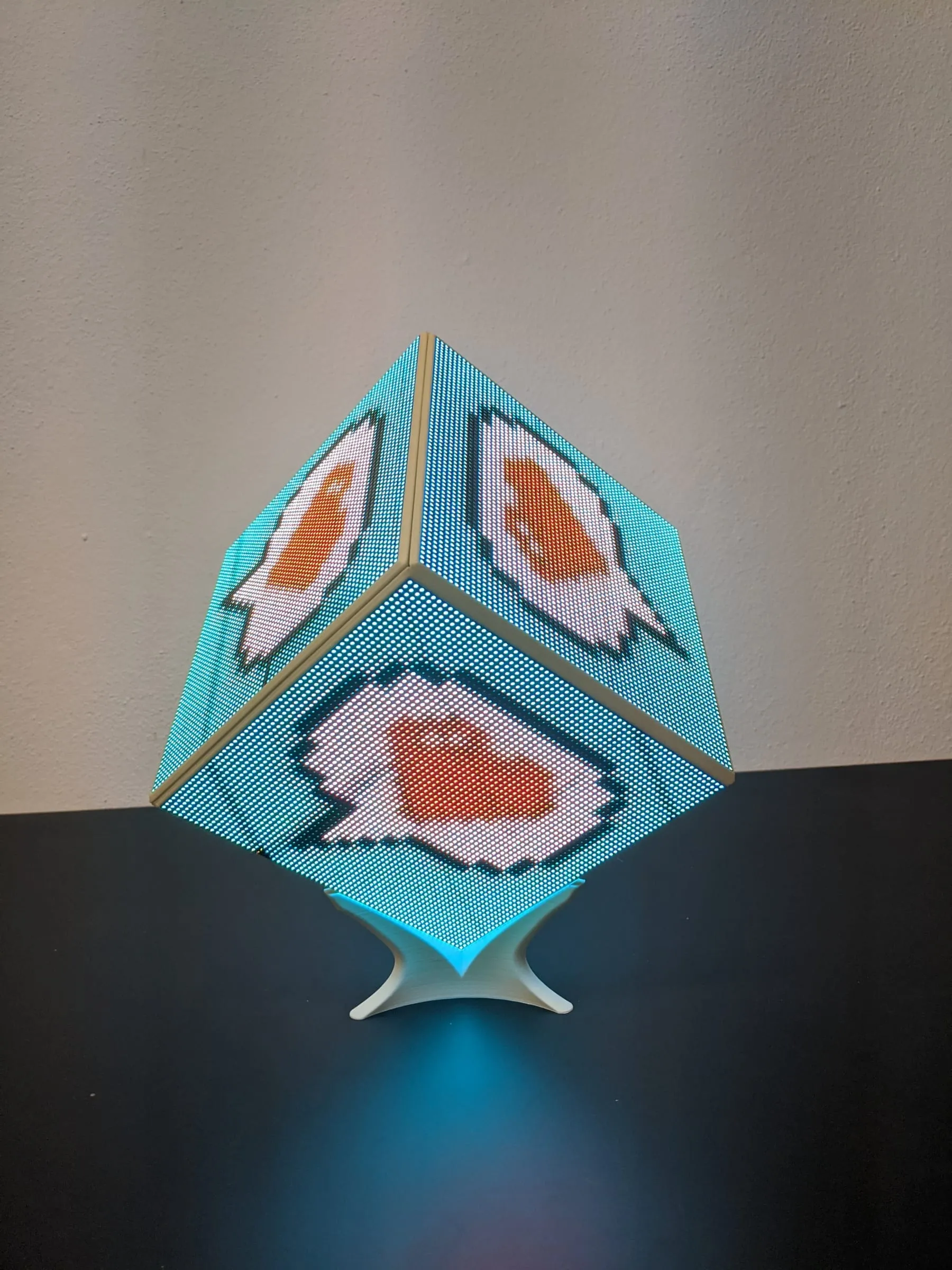 The LED CUBE standing on a table, its faces showing pixel-art animations