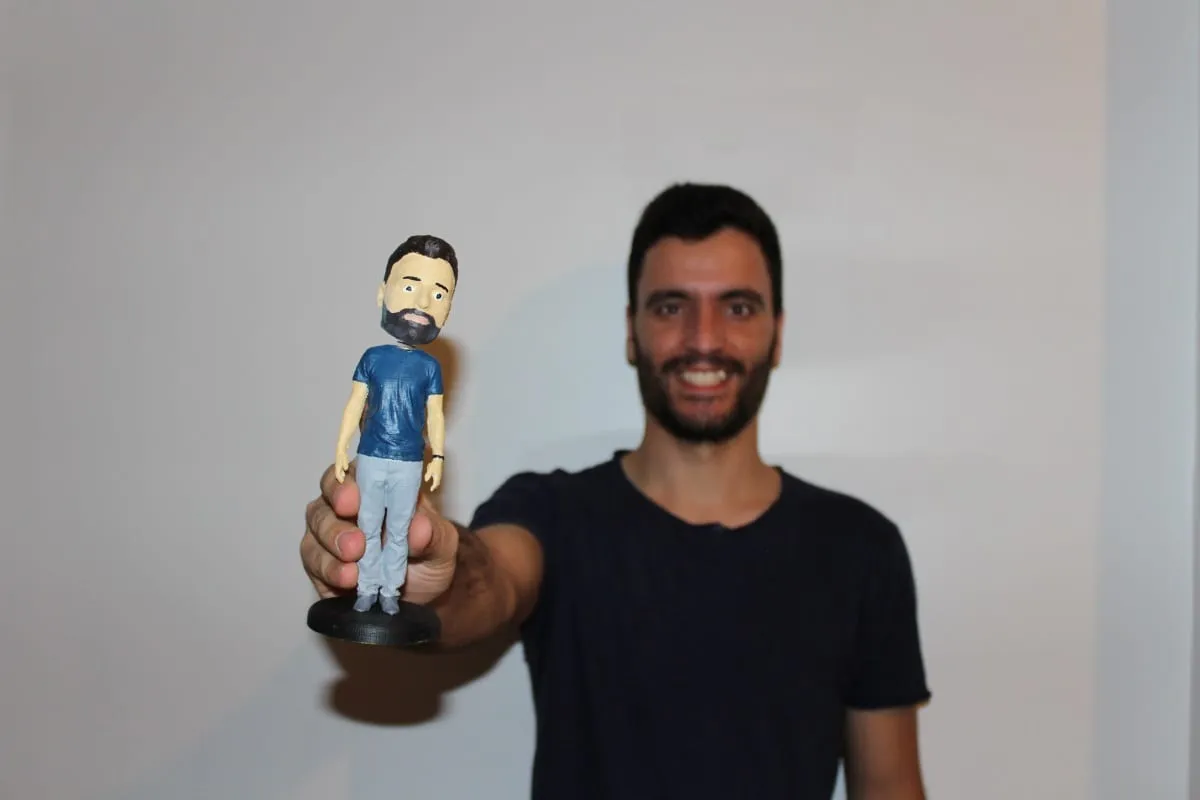 Luís holding the bobblehead made from his own full-body scan