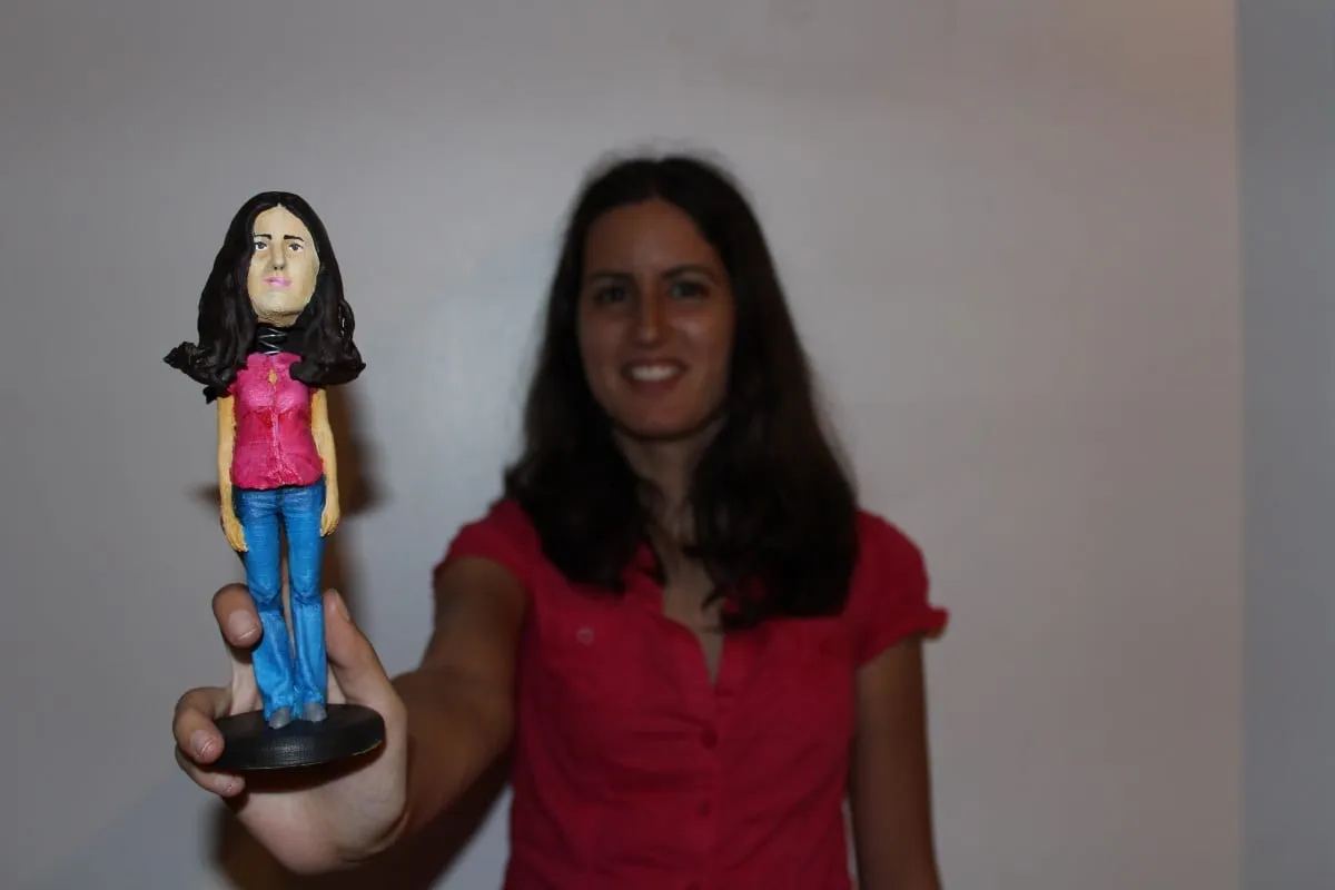 Holding the second bobblehead next to its real-life model