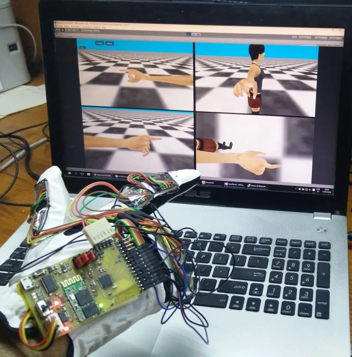 The glove wired to its controller board, with the 3D hand model on screen